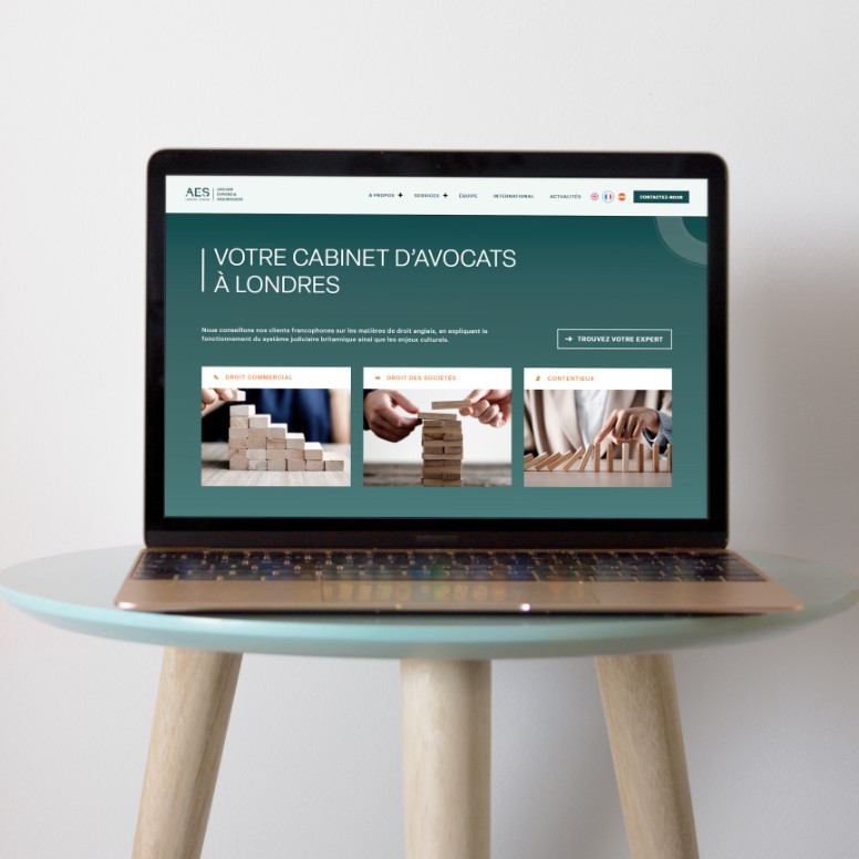 Page d’accueil du site AES Lawyers sur ordinateur portable, UX sobre et multilingue