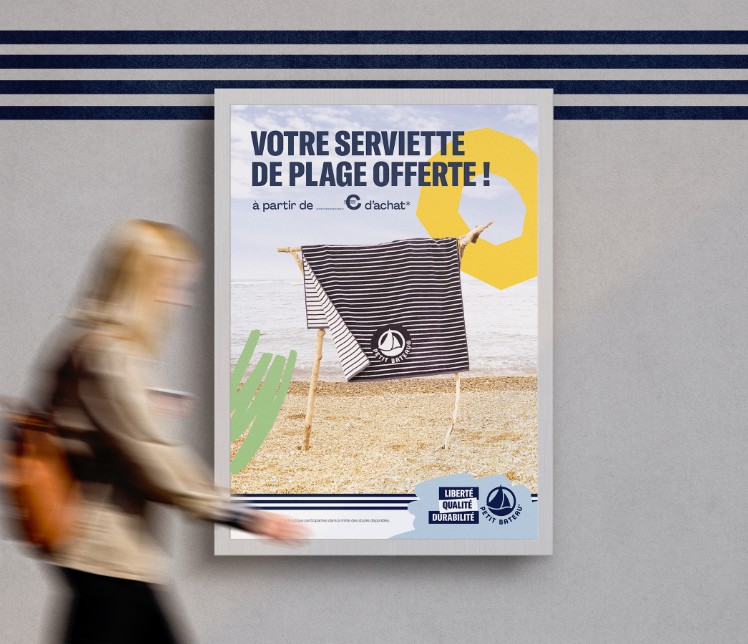 Affiche PLV Petit Bateau pour opération commerciale d'une serviette de plage offerte dès un certain montant d’achat