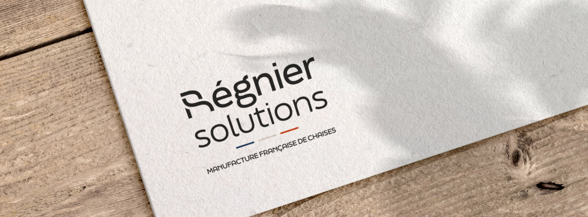 Identité visuelle de Régnier Solutions appliquée à la papeterie, avec une cohérence graphique bois et mobilier
