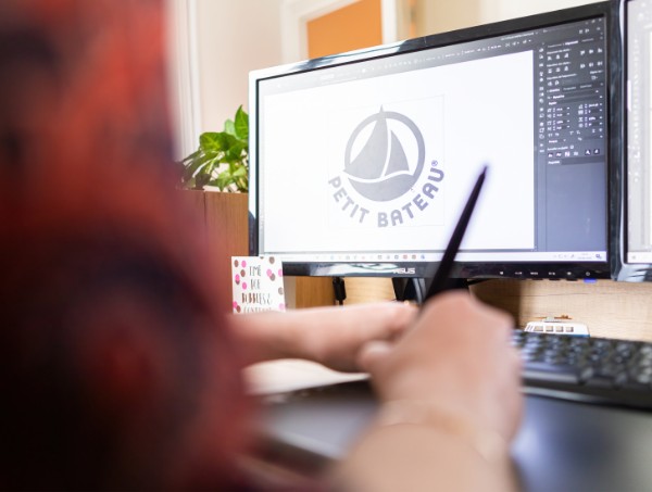 Designer graphique du Studio Ikadia en train de retravailler une mise en page à l'agence de communication à Troyes