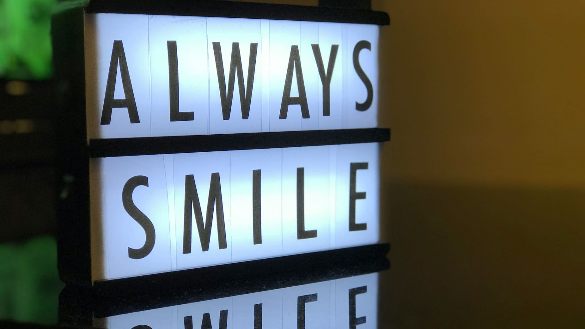 Boîte lumineuse rétroéclairée avec l’inscription « ALWAYS SMILE », illustrant une expérience de marque positive et mémorable 