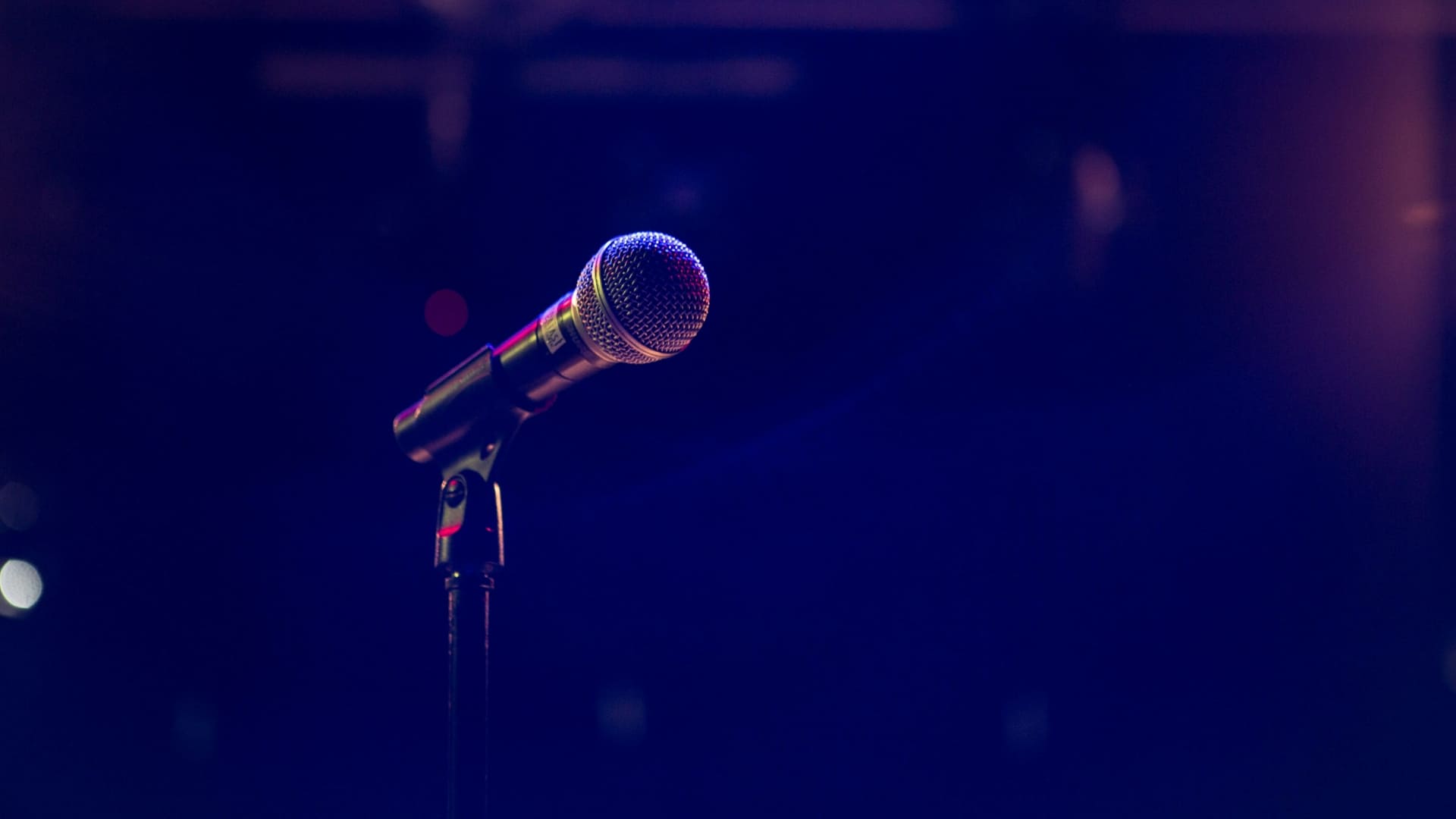 Microphone sur scène dans une lumière tamisée, symbole de la prise de parole d’une marque