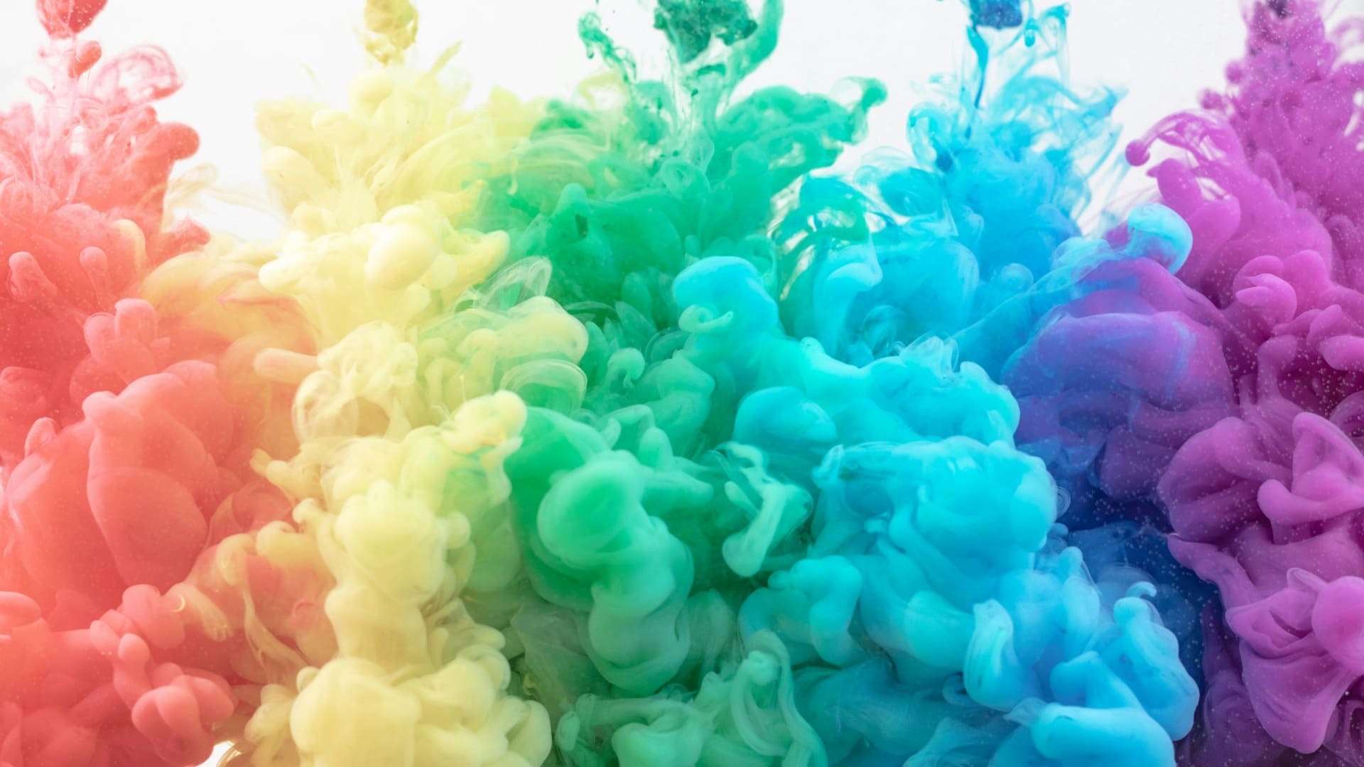 Explosion de pigments multicolores dans l’eau symbolisant la créativité en communication visuelle