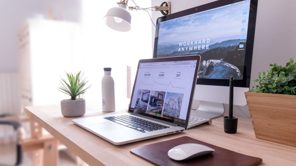 Ordinateurs sur un bureau avec l’inscription 'Work hard everywhere' pour illustrer les efforts déployés quand un site internet ne convertit pas.